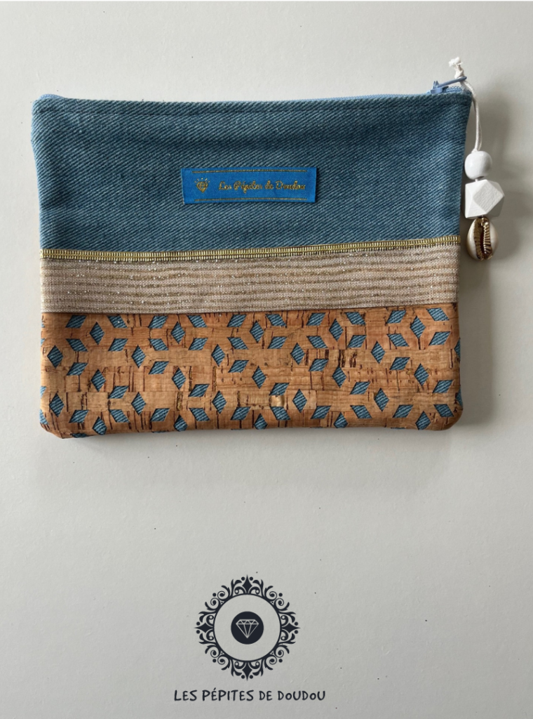 pochette avec fermeture éclaire sur fond blanc jean liège et paillette dorée breloque bois et coquillage